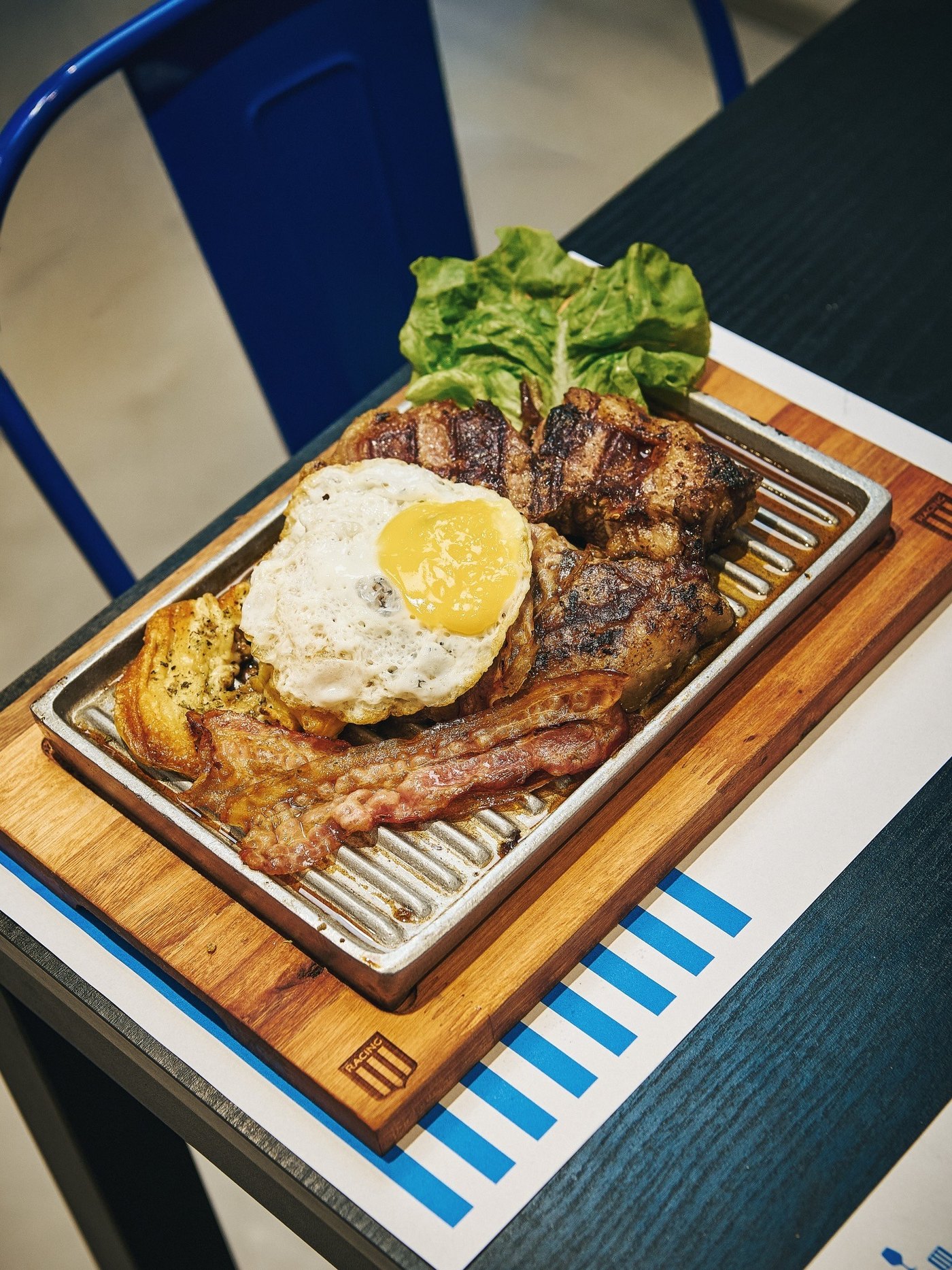 El Gran Bife Costas en tabla de madera, coronado con huevo frito