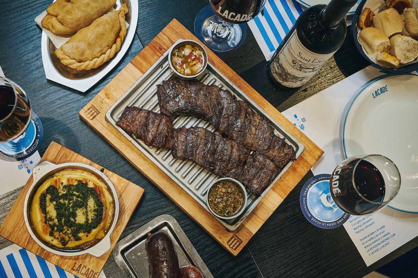 La mesa vista desde arriba, cubierta de tablas de parrilla y vino