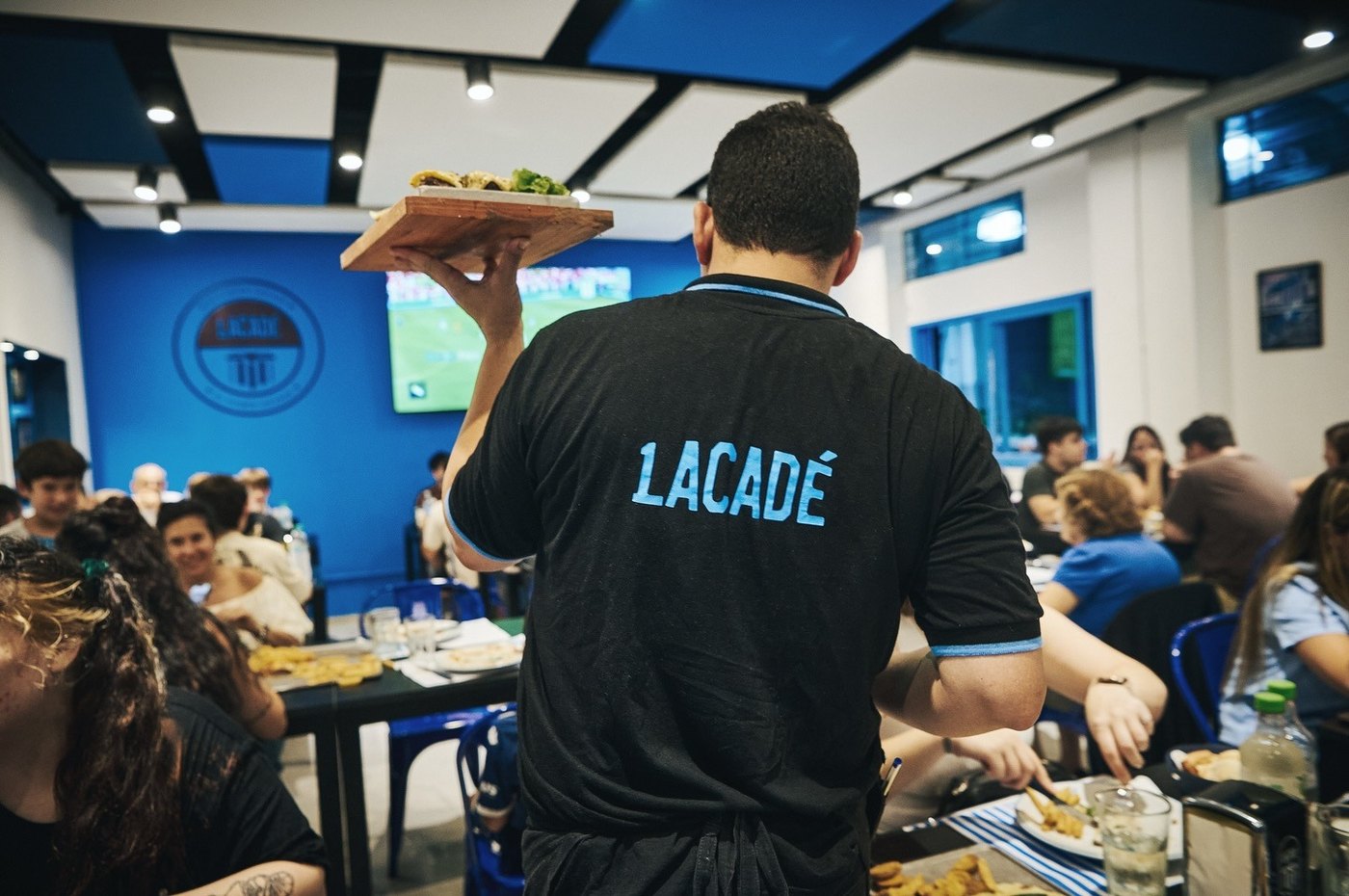 El salón lleno durante el servicio, con el equipo Lacadé trabajando