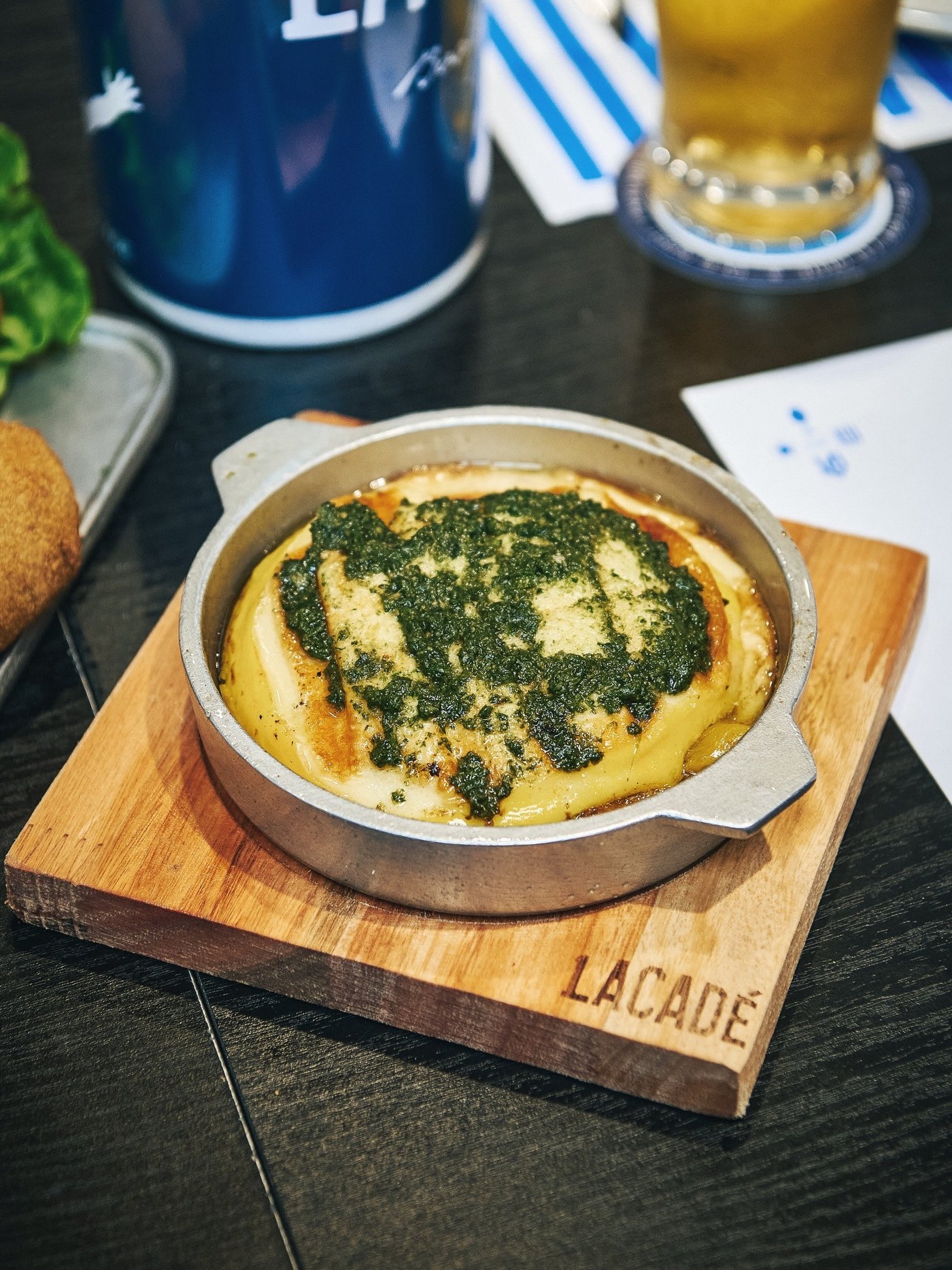 Cazuela recién salida de la cocina sobre tabla de madera con el sello Lacadé